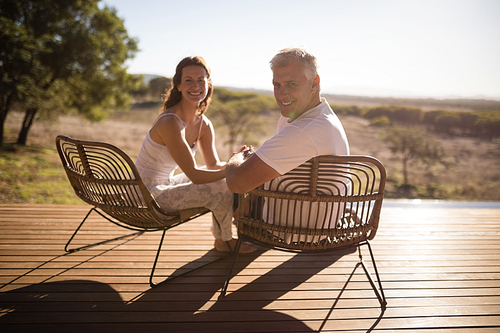 Senior couple sitting on chairs at the resort on a sunny day