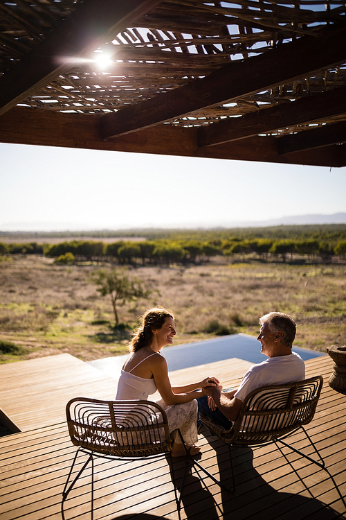 Senior couple sitting on chairs at the resort on a sunny day