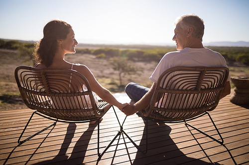 Rear view of senior couple sitting on chairs at the resort