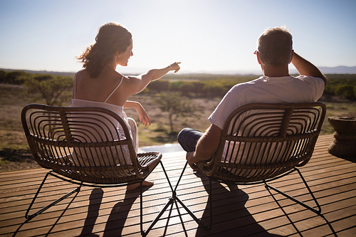 Rear view of senior couple sitting on chairs at the resort