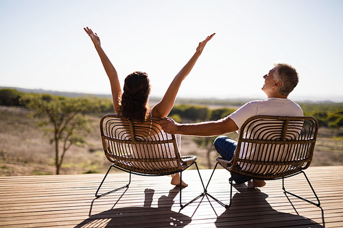 Rear view of senior couple sitting on chairs at the resort