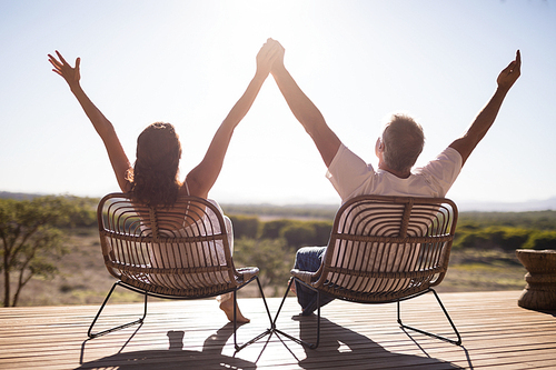 Rear view of senior couple sitting on chairs at the resort