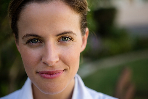 Close up portrait of confident female doctor in park