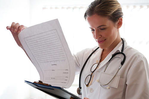Smiling female doctor examining reports in nursing home