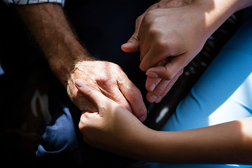 Cropped hands of female doctor consoling senior man in retirement home