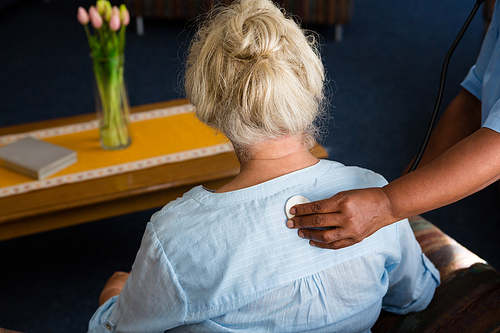 Cropped hand of nurse examining patient in retirement home