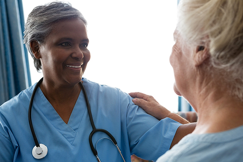 Smiling nurse talking to senior patient in retirement home