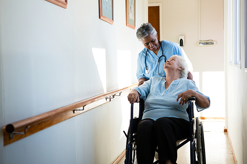 nurse talking while pushing patient sitting in . at nursing home