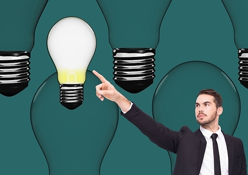 Digital composition of businessman pointing at light bulb against green background