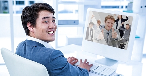 Happy businessman having video call with colleagues on desktop computer