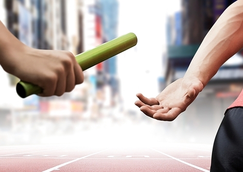 Composite image of athletes passing the baton during relay race against city buildings