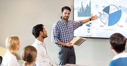 Businessman giving presentation to his colleagues at office