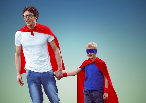 Happy father and son in superhero costume against blue background