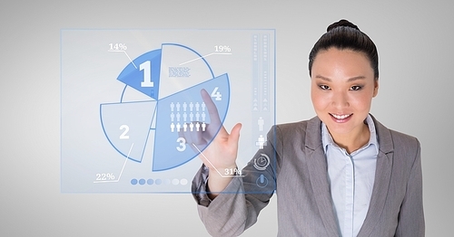 Business woman touching digitally generated pie chart against grey background