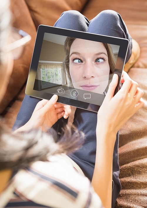 Woman having video call with friend on digital tablet at home