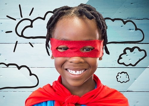Portrait of smiling boy in superhero costume standing against wooden plank background