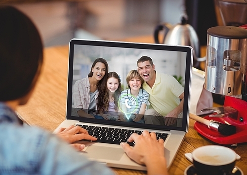 Woman having video call with family on laptop at cafe