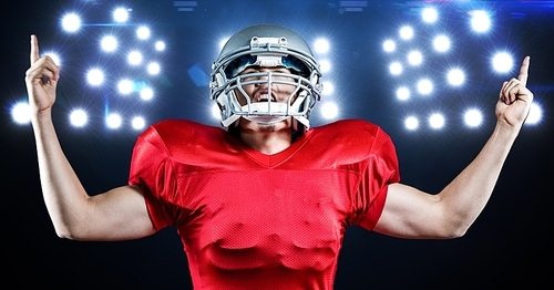 Digital composition of american football player celebrating against floodlights in background