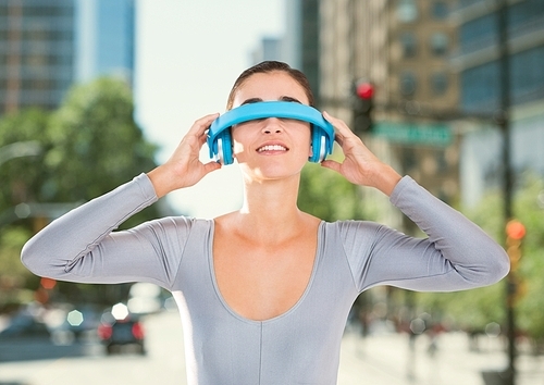 Smiling woman using virtual reality glasses against city in the background