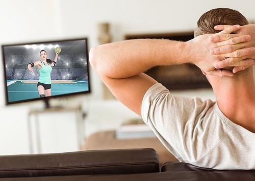 Rear view of man watching handball on television at home