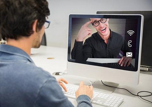 Rear view of man having a video call with his friend on desktop pc