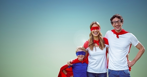 Portrait of father, mother and son in superhero costume standing against green background