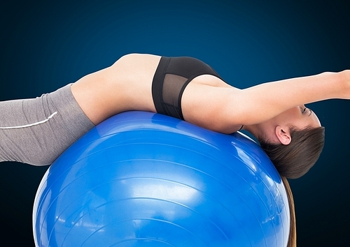 Fitness woman performing exercise using fitness ball against blue background