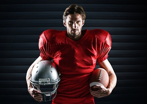 Digital composition of american football player holding rugby ball and helmet against digitally generated background