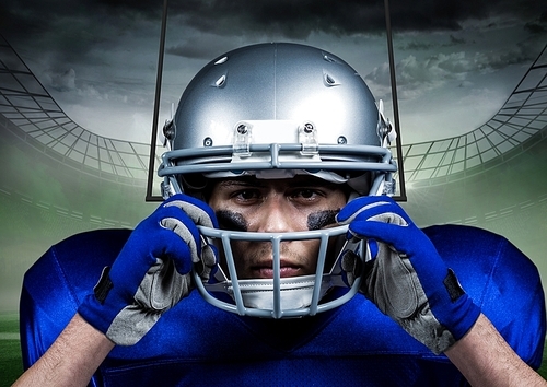 Determined american football player standing against digitally composite stadium