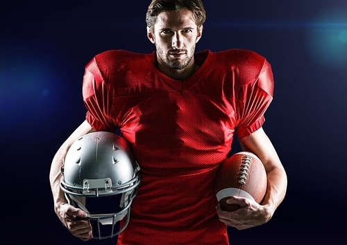 Portrait of confident athlete holding american ball and headwear against digitally composite background