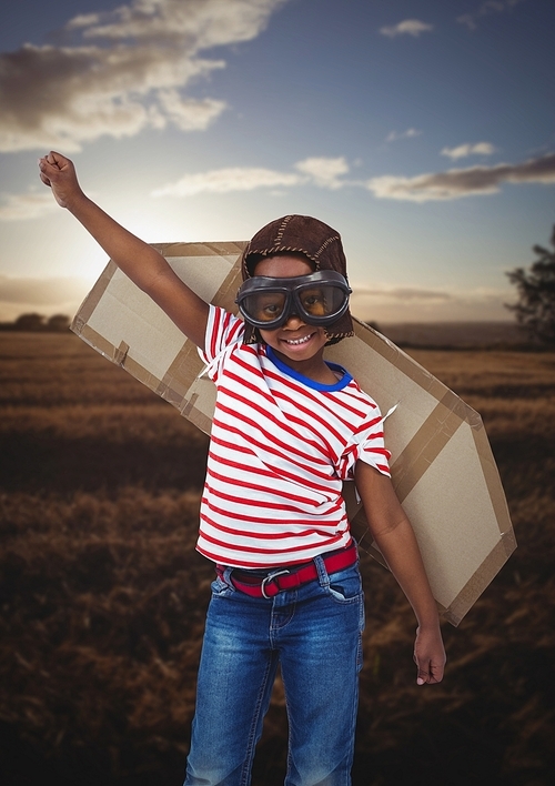 Composite image of smiling kid pretending to be a pilot in field