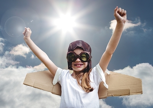 Composite image of excited smiling kid pretending to be a pilot against bright sunlight background
