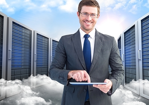 Digitally composite of smiling businessman using digital tablet against server and clouds background