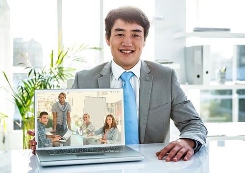 Portrait of smiling businessman having video call on laptop in office