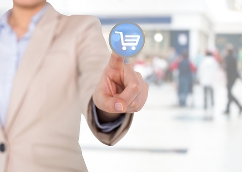 Digital composite image of businesswoman touching interface screen with shopping cart icon