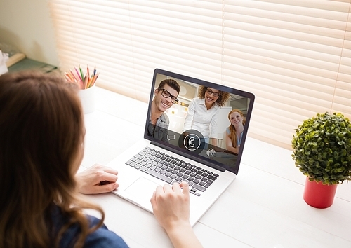 Woman having video call with friends on laptop at home