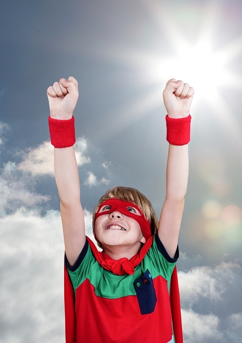 Digital composite image of smiling boy wearing superhero costume against cloudy background