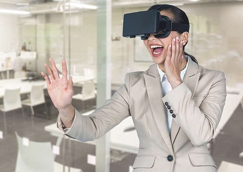 Digital composite image of smiling businesswoman using virtual reality headset in office