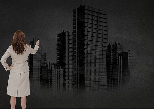 Digital composite image of businesswoman drawing cityscape on wall