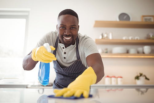 Portrait of smiling man cleaning the kitchen worktop at home