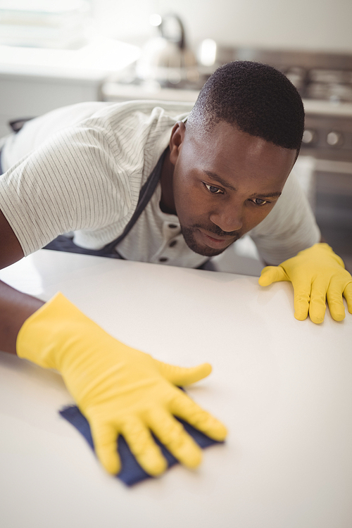 Man cleaning the kitchen worktop at home