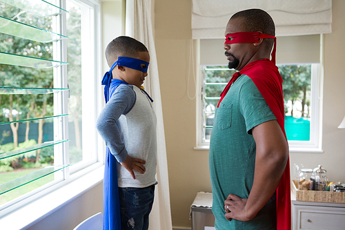 Son and father pretending to be a superhero at home