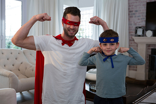 Father and son pretending to be superhero at home