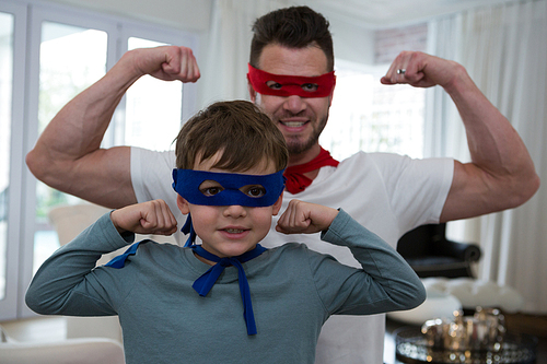 Father and son pretending to be superhero at home