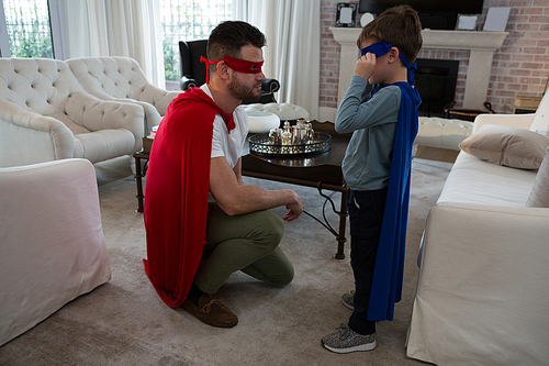 Father and son pretending to be superhero at home