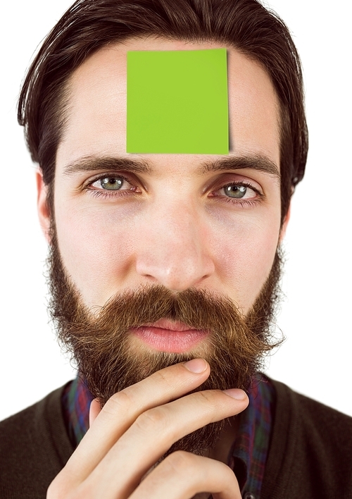 Close-up of businessman with blank sticky note on forehead standing against white background