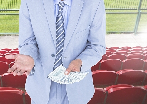 Digitally composite image of corrupt businessman holding money in stadium