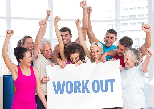 Happy fitness team standing with placard with work out text in gym