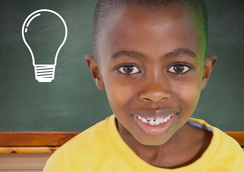 Digital composite of kid smiling against blackboard with lightbulb
