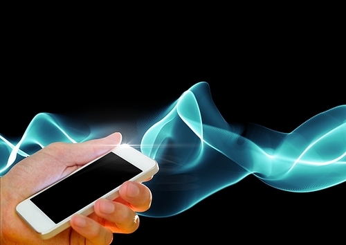 Digital composite of Hand holding cell phone against smoke effects